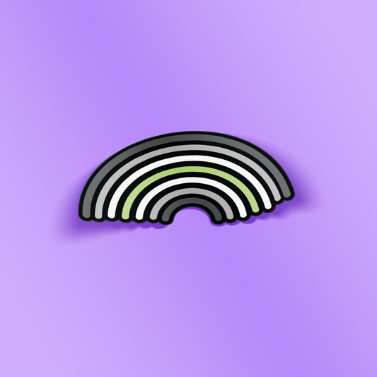 Rainbow sticker with the agenda pride colors, with rounded corners and a black outline. The background behind the sticker is purple.