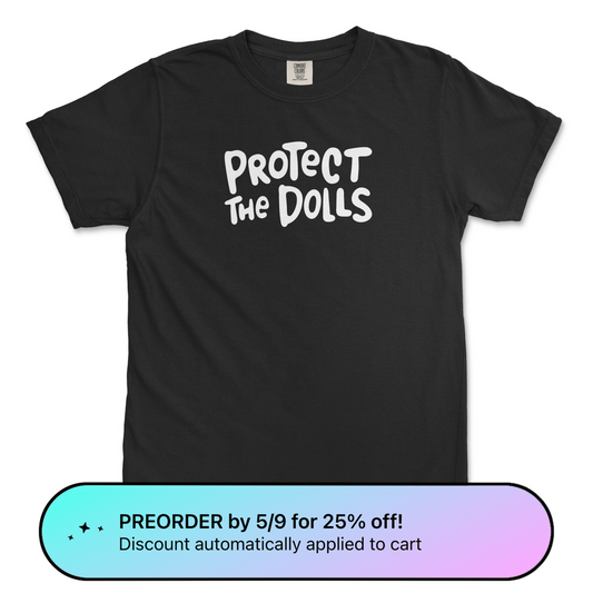 Black Comfort Colors trans rights shirt with hand written text that says "Protect the Dolls" in white.